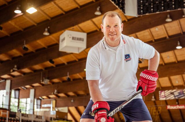 Icehockey Trainer mit Handschuhen und Schläger in Halle