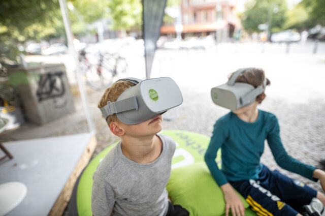 Zwei Kinder probieren die VR Brille aus zur Aktion in Berlin
