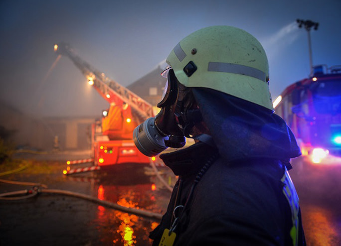 Feuerwehrmann im Profil vor einem Löschzug