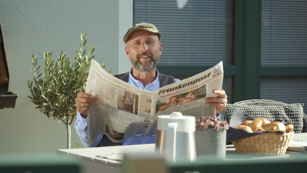 Werner mit Zeitung am Frühstückstisch